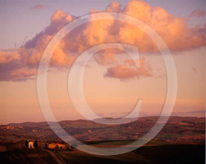  2003 - Landscapes of church and farm with orange clouds on sunset in autumn, near Pienza village, Orcia valley, 20 miles south the province of Siena.