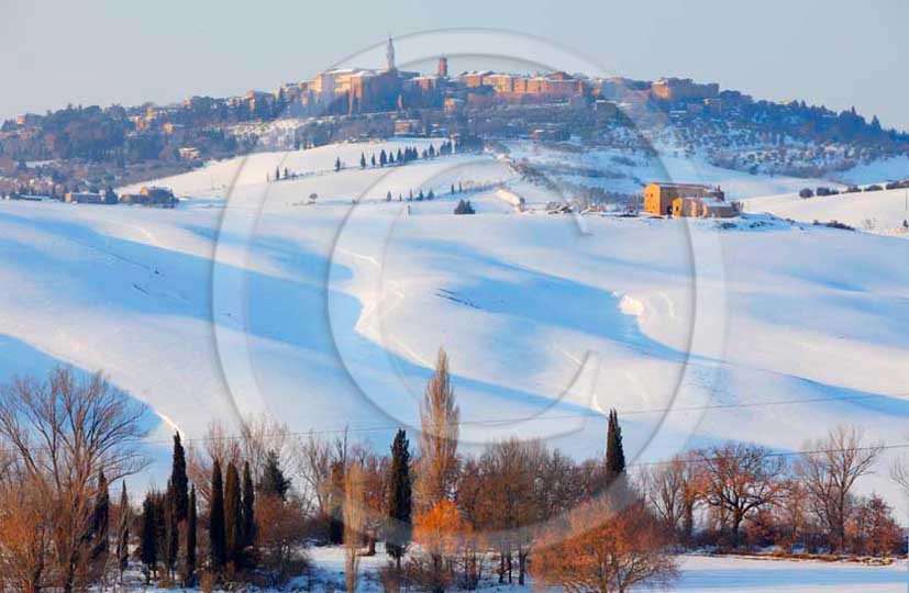 2012 - View of farm, cypress line with snow in winter in Orcia valley.