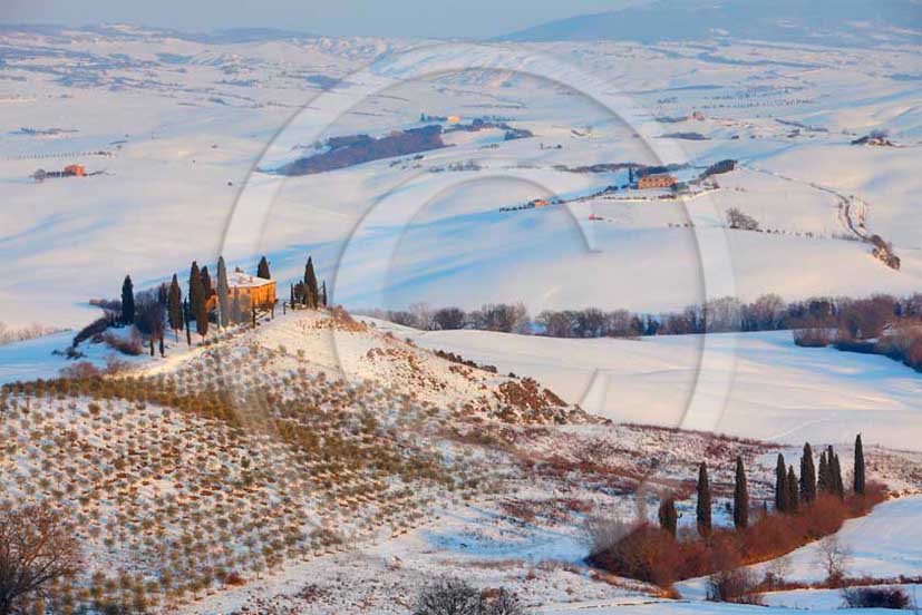 2012 - View of farm, cypress line with snow in winter in Orcia valley.