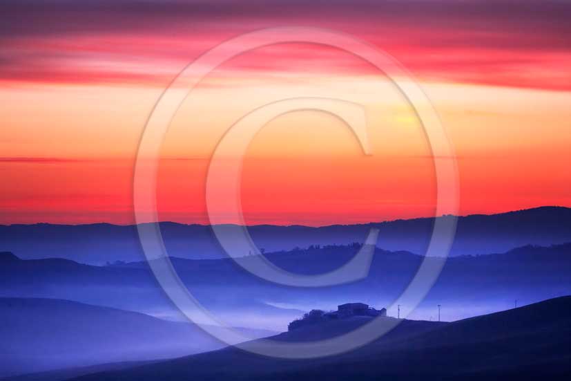 2013 - View of sunrise tuscan skyline of farm and cipress near san Giovanni D'Asso village in Crete Senesi land.