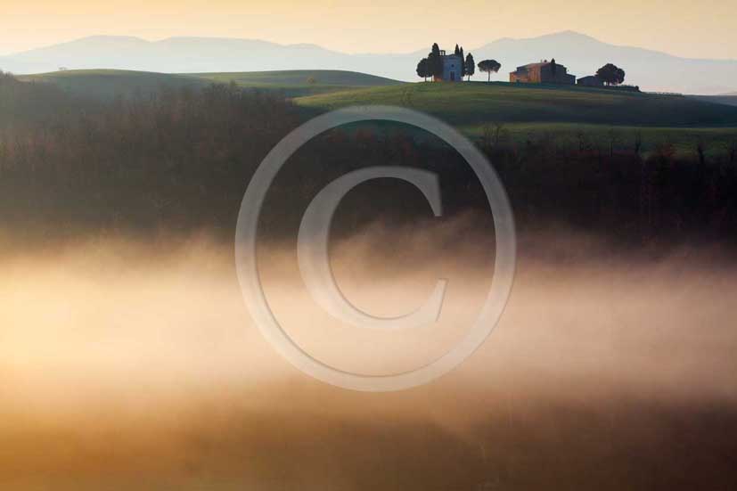 2009 - Landscapes of farm with country chapel and cipress with fog on sunrise in winter, near S.Quirico village, Orcia valley, 22 miles south province of Siena.