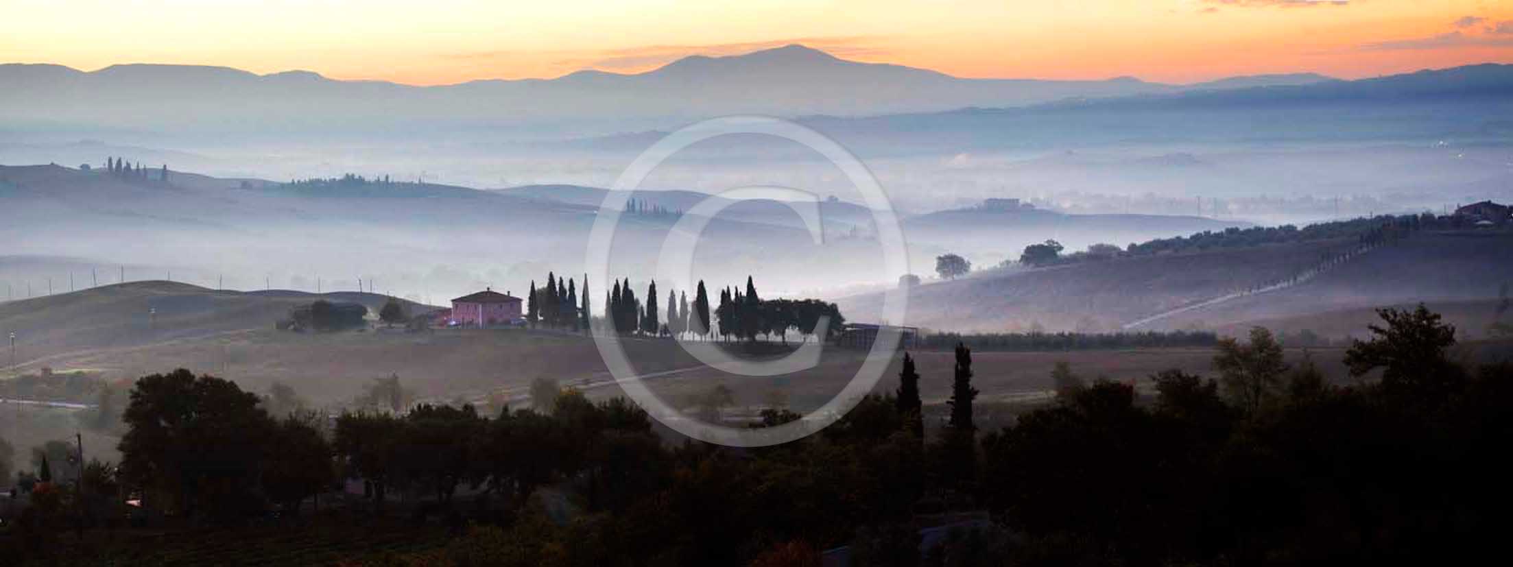 2011 - Panoramic view of cypress ans tuscan skyline with farm and cipress at sunrise in Orcia valley.